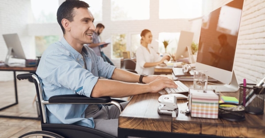 man in wheelchair on computer
